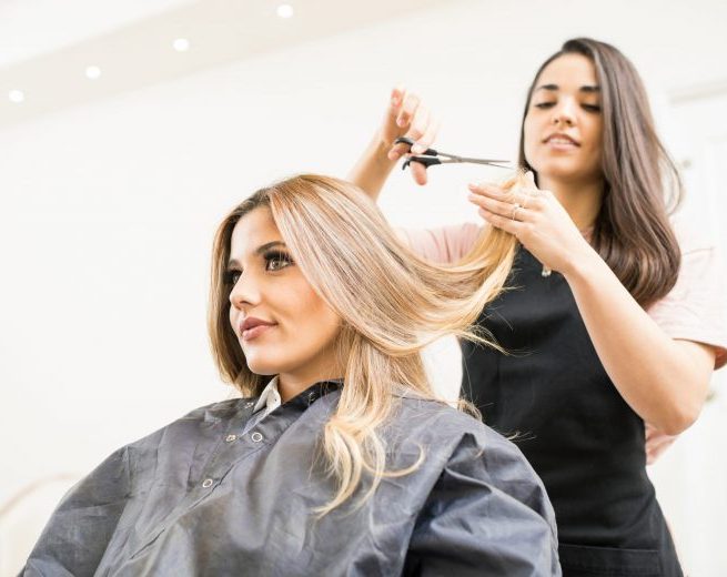 Female stylist cutting woman's hair