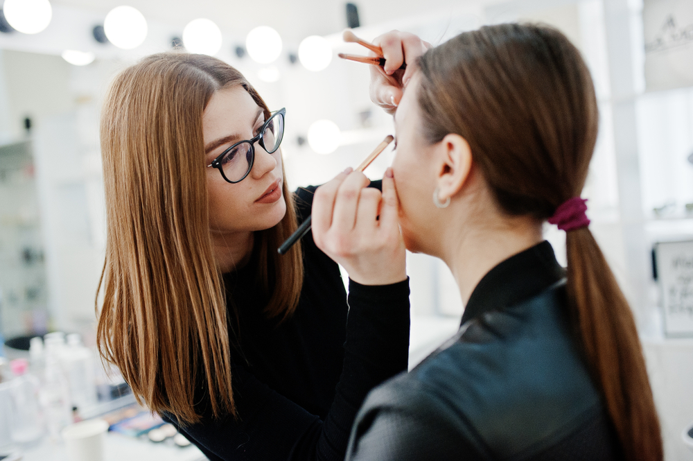 makeup artist helping client